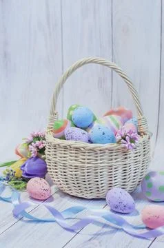 Basket with painted Easter eggs on a light wooden background, Easter card Stock Photos