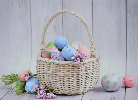 Basket with painted Easter eggs on a light wooden background, Easter card Stock Photos