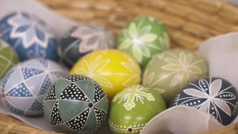 Basket of pastel-colored Easter eggs with traditional folk patterns in soft Stock Footage 307188230