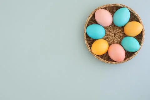 Basket with pastel Easter eggs on a light blue background with space for text Stock Photos