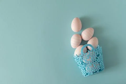 Basket with Pastel Pink Easter Eggs on Blue Background. Minimal Festive Com.. Stock Photos