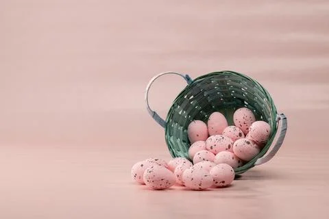 Basket with pink eggs on a light background during spring celebration Stock Photos