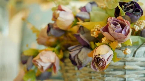 Basket rose artificial flowers on table Stock Footage 93598189