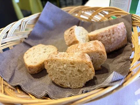 A basket of rustic bread slices on a linen cloth. Stock Photos