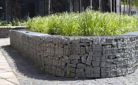 Basket support wall made of granite gabion. Gabions in the garden. Modern Gab Stock Photos