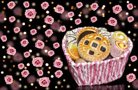 Basket of sweets on the background of falling roses and bokeh. Selective focus 写真素材