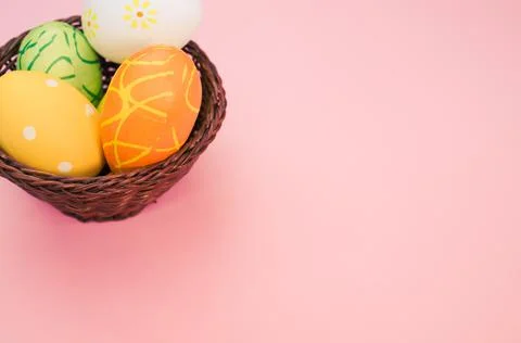 Basket with various easter eggs on pink background with space for text 写真素材