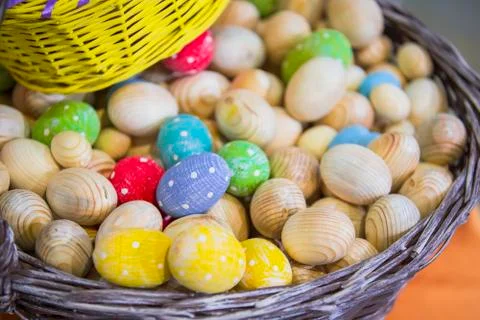 Basket with wooden workpieces of Easter eggs, eggs colored in different color Stock Photos