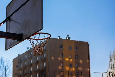 Basketball backboard with a basket in front of a multi-storey building. Stock Photos