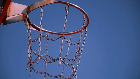 Basketball ball twice fall through basket with chain net on sunny day close up. Stock Footage 110618394