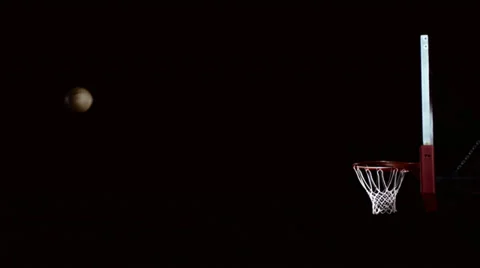 A basketball floats through the air and then swishes through the net Stock Footage