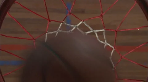 A basketball goes into the net and a player picks it up. Stock Footage