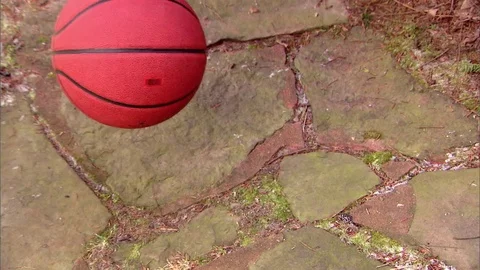 Basketball high angle dropped on cobblestone sidewalk Stock Footage 76404756