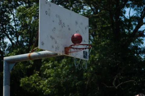 Basketball Hovering Over the Net Stock Photos