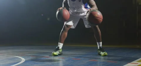 Basketball player dribbles two balls, dark cinematic shot, slow motion Stock Footage 140264609