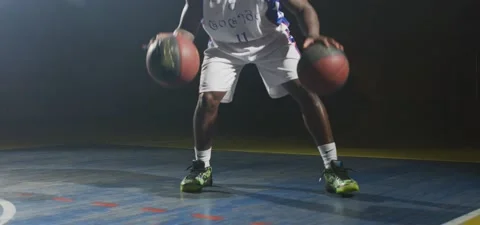 Basketball player dribbles two balls, dark cinematic shot, slow motion Stock Footage 140264726
