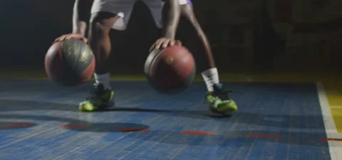 Basketball player dribbles two balls, dark cinematic shot, slow motion Stock Footage 140264807