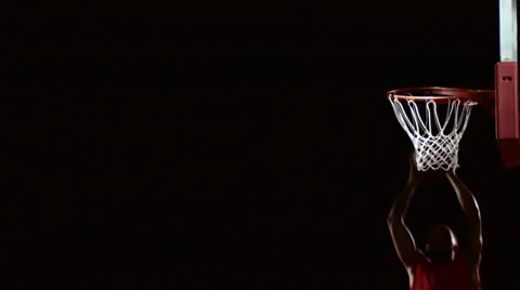 A basketball player dunks the ball in the shadows Stock Footage 33993890