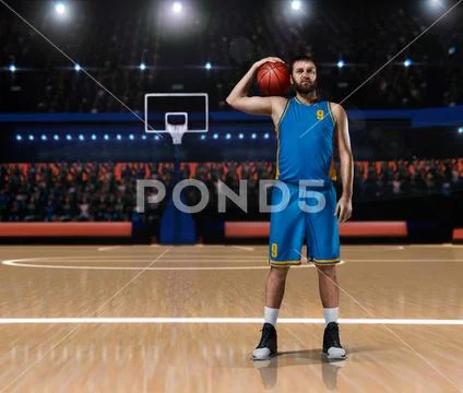 Basketball player im blue uniform standing on basketball court Stock Photos