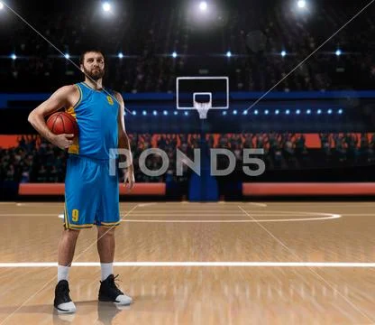 Basketball player im blue uniform standing on basketball court Stock Photos