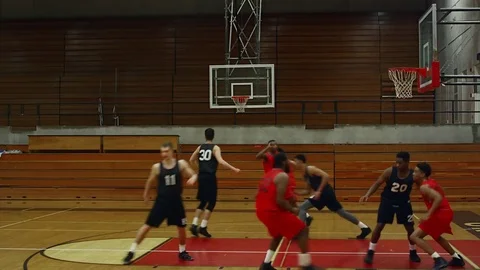 A basketball player makes a slam dunk during a game Vídeo Stock 70681476