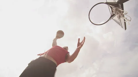 Basketball player making a slam dunk on a bright sunny day Stock Footage 41776179