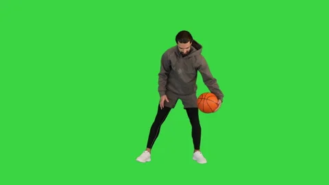 Basketball Player In Outdoor Clothes Bouncing A Ball on a Green Screen, Chroma Stock-Footage 157063984