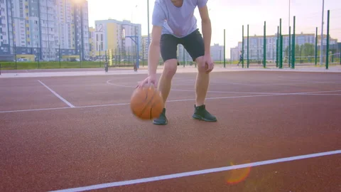 Basketball player playing with a ball, training on an outdoor sports ground Stock Footage 309854036