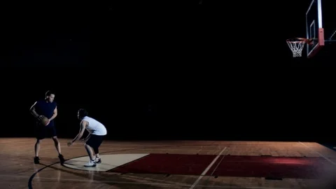 A basketball player shoots a three pointer over defender and makes it. Stock Footage 83608235