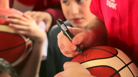 Basketball player signed autograph on ball for children fans Stock Footage