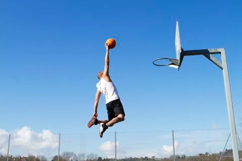 people playing basketball outside dunking