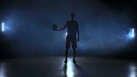 Basketball player throws and catches the ball in the smoke Stock Footage 100424010