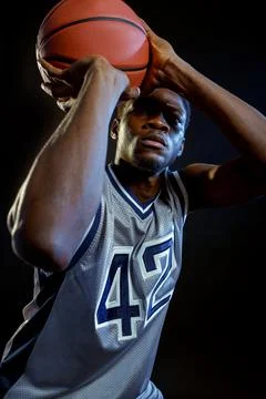 Basketball player throws a ball in studio Stock Photos