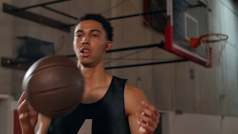 Basketball player tosses a ball back and forth and spins it on his finger Video stock 70688045