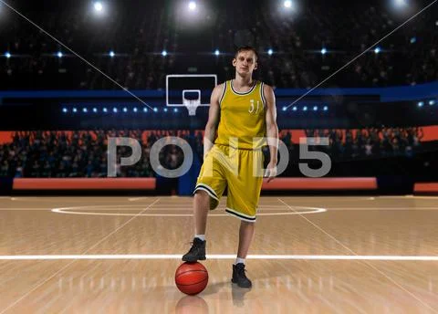 Basketball player in yellow uniform standing on basketball court Stock Photos
