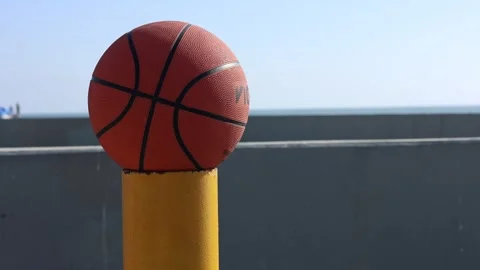 Basketball In Sunlight On Yellow Parking Lot Post Stock-Footage 336344341