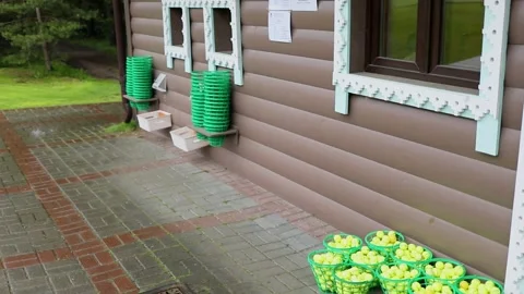 Baskets with balls near wall of golf club building during rain Vídeos de archivo 276368931