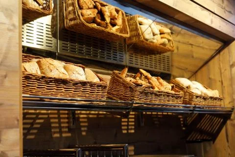 Baskets with different types of bread on the shelf Stock Photos
