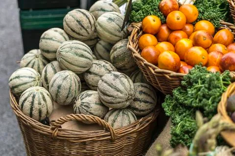 Baskets with small melons and many oranges for sale at market Stock Photos