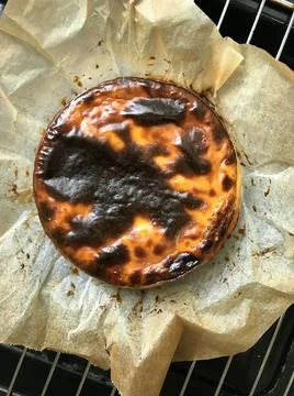 Basque burnt cheesecake in baking paper Stock Photos