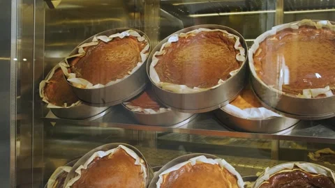 Basque burnt cheesecakes in a showcase of pastry shop. Delicious San Sebastian Video stock 256245331