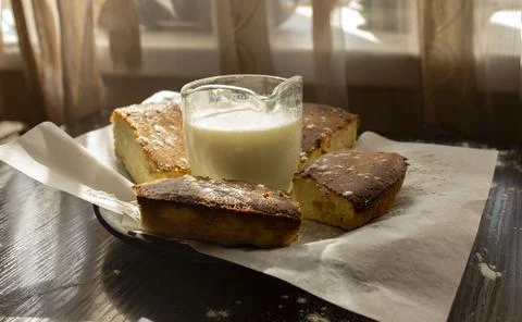 Basque cheesecake with milk on the table in the sun Stock Photos