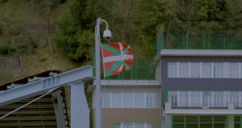 Basque Country flag flys in wind atop building in San Sebastián, northern Stock Footage 154436554