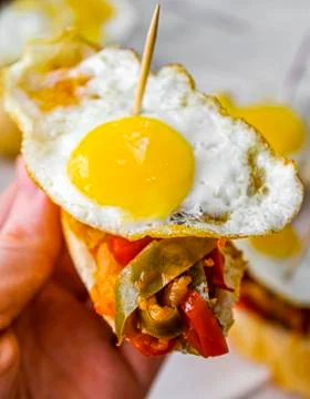 Basque pintxo made with onion, red &amp; green pepper topper with a small fried e Stock Photos