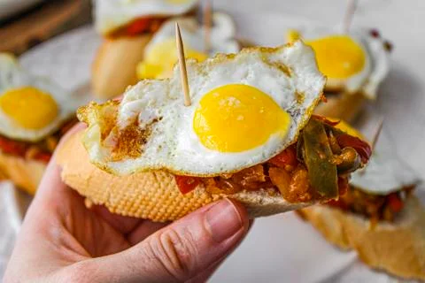 Basque pintxo made with onion, red &amp; green pepper topper with a small fried e Stock Photos