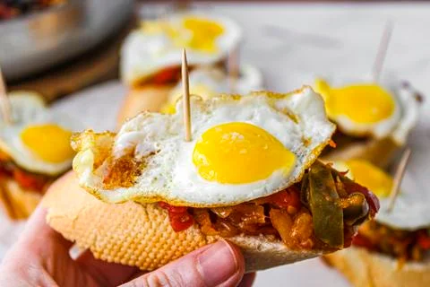 Basque pintxo made with onion, red &amp; green pepper topper with a small fried e Stock Photos
