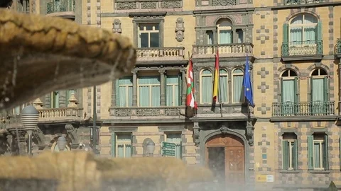Basque, Spanish and EU flags flapping on Chavarri Palace facade in Bilbao center Stock Footage 73779175