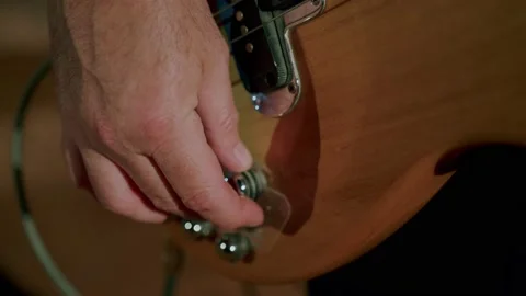 Bass guitar player adjusting knobs before show 動画素材 166486343