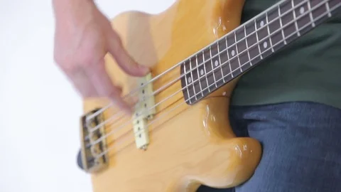 Bass guitar player fingers on the strings close-up isolated on white 動画素材 82189072