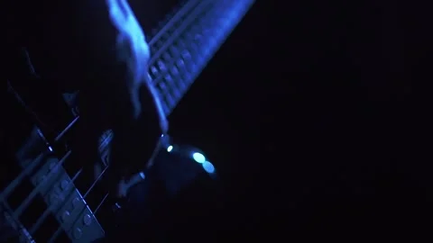 Bass player performing in blue light and slow motion Stock Footage 318551887